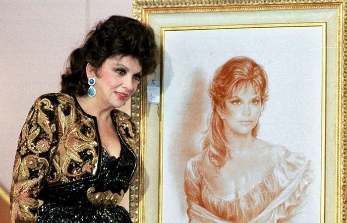 Фото. Итальянская актриса Джина Лоллобриджида рядом со своей фотографией в молодости на телевизионном аукционе 19 октября 1999 года в Каире. Фотография была продана за тыс, а платье — за  тыс. (AMR NABIL/AFP via Getty Images)