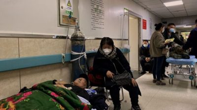 Пациент с COVID-19 лежит на кровати в коридоре больницы Таншань Гунжэнь в городе Таншань на северо-востоке Китая, 30 декабря 2022 года. (Ноэль Селис/AFP через Getty Images)
