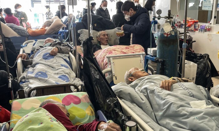 Пациенты на носилках в больнице Тунжэнь в Шанхае, 3 января 2023 года. (Hector Retamal/AFP via Getty Images)
