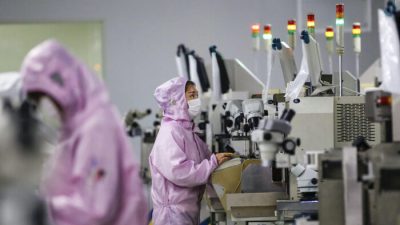Китайские рабочие в масках и защитных костюмах работают на линии по производству смарт-чипов в Сихонге в восточной китайской провинции Цзянсу, 16 февраля 2020 года. (STR/AFP)
