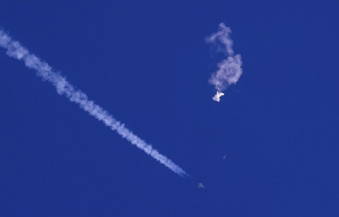 На этой фотографии, предоставленной Чадом Фишем, остатки большого воздушного шара дрейфуют над Атлантическим океаном, недалеко от побережья Южной Каролины, а под ним виден истребитель и его инверсионный след, 4 февраля 2023 года. (Chad Fish via AP)