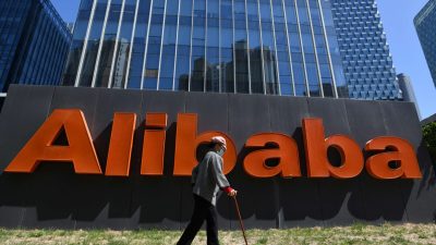 Женщина проходит мимо вывески Alibaba возле офиса компании в Пекине, Китай, 13 апреля 2021 года. (Greg Baker/AFP via Getty Images)