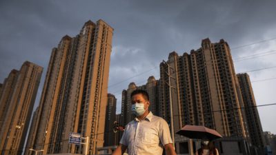 Мужчина в маске во время прогулки по сообществу Evergrande Changqing в Ухане, провинция Хубэй, Китай, 24 сентября 2021 года. (Getty Images)