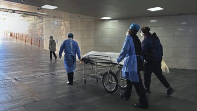 Работники больницы и родственник вывозят тело на каталке из загруженного отделения неотложной помощи в больнице в Пекине, Китай, 2 января 2023 года. (Getty Images)
