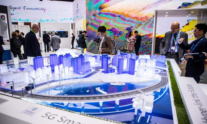 Посетители знакомятся с технологией 5G Smart City на стенде China Mobile на GSMA Mobile World Congress 2019 в Барселоне, Испания, 26 февраля 2019 года. В этом ежегодном конгрессе принимают участие некоторые из крупнейших мировых коммуникационных компаний, многие из которых представляют свои новейшие телефоны и носимые гаджеты, такие как складные экраны и внедрение беспроводных сетей 5G. (David Ramos/Getty Images)
