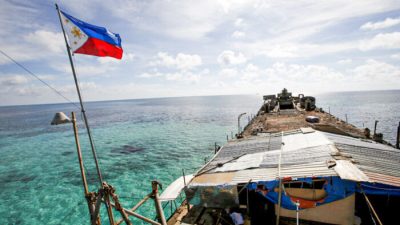Филиппинский флаг развевается над BRP Sierra Madre, ветхим кораблём филиппинских ВМС, который в 1999 году сел на мель и с тех пор является филиппинским военным форпостом на спорной Второй отмели Томаса, являющейся частью островов Спратли, в Южно-Китайском море, 29 марта 2014 года. (Erik De Castro/Reuters)
