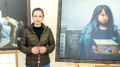 Посетительница выставки «Истина-Доброта-Терпение — искусство, дарованное свыше» актриса Кристина у картины «Печаль сироты». (The Epoch Times)
