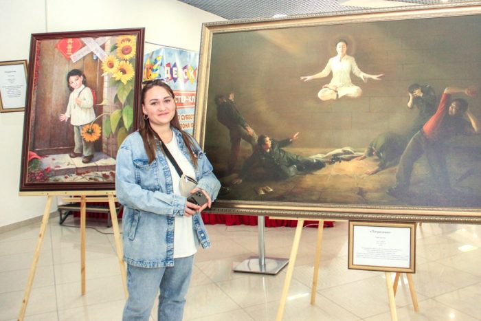 Фотограф Александра у картины «Потрясение». (The Epoch Times)
