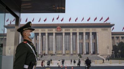 Полицейский стоит на страже перед заключительным заседанием Народного политического консультативного совета Китая в Доме народных собраний в Пекине, Китай, 10 марта 2022 года. (Kevin Frayer/Getty Images)