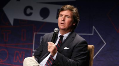 Ведущий Fox News Такер Карлсон выступает на сцене Politicon 2018 в конференц-центре Лос-Анджелеса 21 октября 2018 г. (Rich Polk/Getty Images for Politicon)
