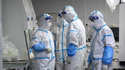 Лаборанты в средствах индивидуальной защиты работают с образцами для тестирования на COVID-19 в лаборатории Fire Eye, центре тестирования на COVID-19, в Ухане, провинция Хубэй, Китай, 4 августа 2021 года. (STR/AFP via Getty Images)
