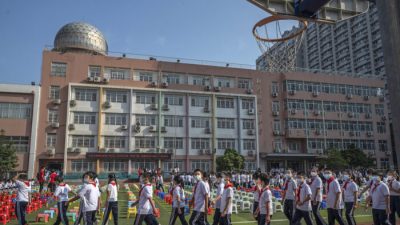 Ученики прибывают на церемонию в первый день нового учебного года в начальной школе в Пекине, Китай, 1 сентября 2021 года. (Kevin Frayer/Getty Images)
