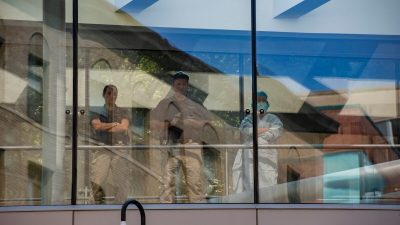 Медицинские работники и полиция наблюдают за демонстрантами, выступающими в поддержку транс-детей и процедур по смене пола, на митинге у здания Бостонской детской больницы в Бостоне, штат Массачусетс, 18 сентября 2022 г. (Joseph Prezioso/AFP via Getty Images)