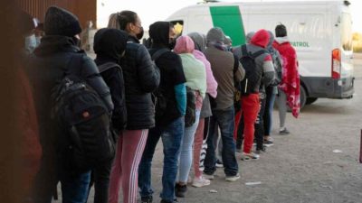 Незаконные иммигранты, ищущие убежища, выстраиваются в очередь для обработки агентами таможни и пограничной службы США у пролома в заборе на границе США и Мексики недалеко от Сан-Луиса, штат Аризона, 26 декабря 2022 года. (Rebecca Noble/AFP via Getty Images)
