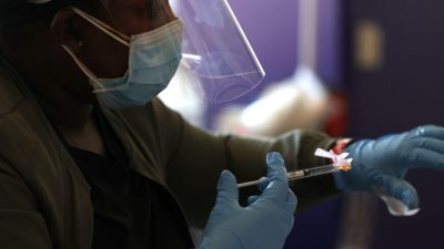 Медсестра вводит вакцину от COVID-19 во время мероприятия, проводимого «Сан-Франциско 49ерс» и другими группами в Санта-Кларе, Калифорния, 8 апреля 2021 года. (Justin Sullivan/Getty Images)