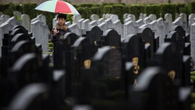 Мальчик стоит между могилами во время ежегодного фестиваля Цинмин, или Дня подметания могил, на общественном кладбище в Шанхае 6 апреля 2015 года. (Johannes Eisele/AFP/Getty Images)