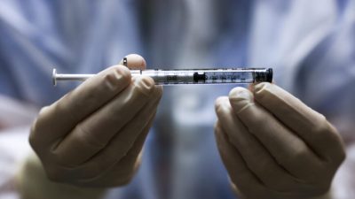 Человек держит шприц с вакцинойJohnson&Johnson против COVID-19 в Авроре, штат Колорадо, 15 декабря 2020 года. (MichaelCiaglo/GettyImages)