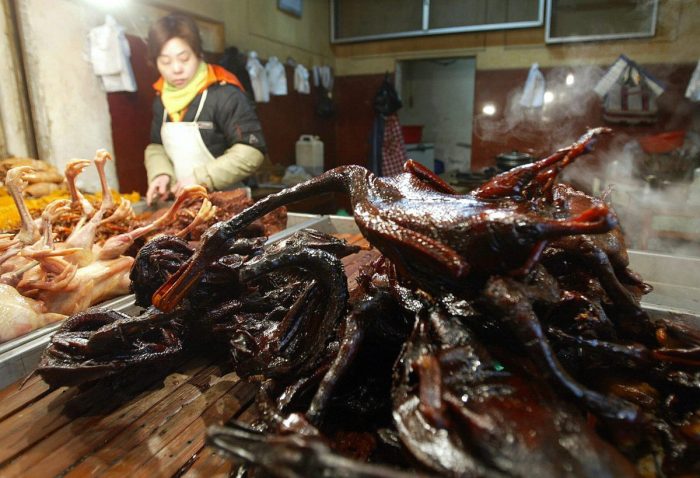 Приготовленные утки и куры продаются на рыночном прилавке в Пекине 30 января 2004 года. (Frederic J. Brown/AFP/Getty Images)