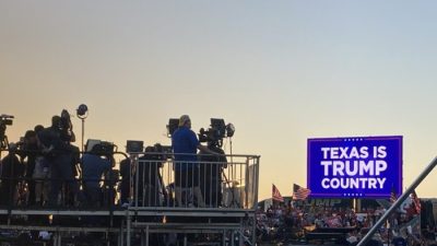 Солнце садится за щит «Техас — страна Трампа», закончился организованный Дональдом Трампом митинг и съёмочные группы начинают собирать оборудование, региональный аэропорт Уэйко, 25 марта 2023 г. (Janice Hisle/The Epoch Times)
