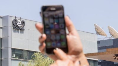 Израильтянка пользуется своим iPhone перед зданием НСО в Герцлии, недалеко от Тель-Авива, 28 августа 2016 года. (Jack Guez/AFP via Getty Images)