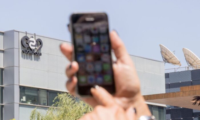 Израильтянка пользуется своим iPhone перед зданием НСО в Герцлии, недалеко от Тель-Авива, 28 августа 2016 года. (Jack Guez/AFP via Getty Images)
