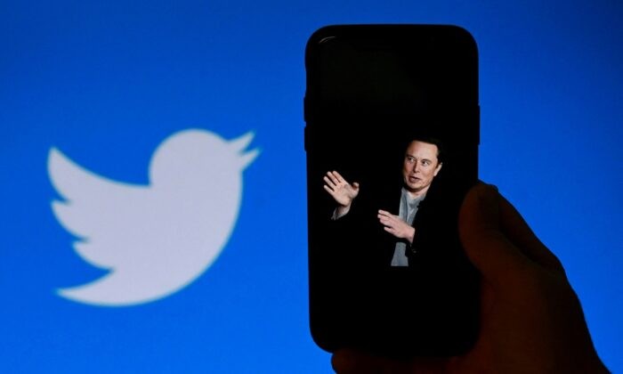 На экране телефона отображается фотография Илона Маска с логотипом Twitter на заднем плане в Вашингтоне 4 октября 2022 года. (Olivier Douliery/AFP via Getty Images)
