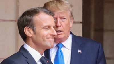 Президент Франции Эммануэль Макрон беседует с тогдашним президентом Дональдом Трампом перед встречей в префектуре Кана, в кулуарах празднования дня «Д», посвящённого 75-й годовщине высадки союзников во время Второй мировой войны в Нормандии, Франция, 6 июня 2019 года. (Ludovic Marin/Pool via Reuters)