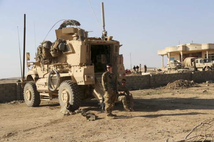 <em>Солдаты армии США стоят возле своего бронетранспортёра на совместной базе с иракской армией к югу от Мосула, Ирак, 23 февраля 2017 г. (Khalid Mohammed/AP)</em>