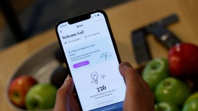Мужчина показывает приложение на телефоне Android на фотографии из файла. (JACK GUEZ/AFP via Getty Images)