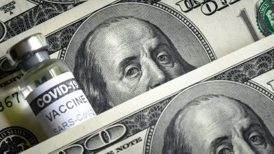 Флакон с вакциной от COVID и купюры в 100 долларов. (Viacheslav Lopatin/Shutterstock)
