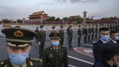 Полицейские и охрана осуществляют контроль за толпой после официальной церемонии поднятия флага рядом с площадью Тяньаньмэнь и Запретным городом в Пекине, Китай, 1 октября 2021 года. (Kevin Frayer/Getty Images)