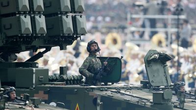 Солдат Народно-освободительной армии Китая стоит на танке во время парада в честь 70-летия захвата Китая Коммунистической партией на площади Тяньаньмэнь в Пекине 1 октября 2019 года. (Andrea Verdelli/Getty Images)

