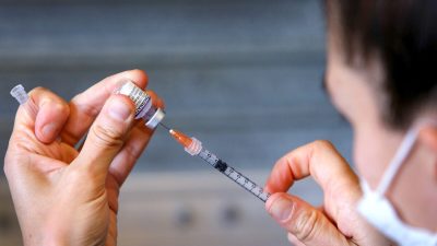 Медсестра готовит вакцину компании Pfizer, 3 октября 2021 года. (Lisa Maree Williams/Getty Images)