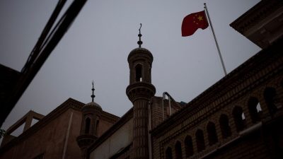 Китайский государственный флаг развевается над мечетью в старом городе в Кашгаре, Синьцзян-Уйгурский автономный район, Китай, 4 мая 2021 года. (Thomas Peter/Reuters)