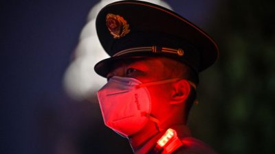 Китайский военизированный полицейский стоит на страже набережной Бунда во время празднования Национального дня Китая в Шанхае 1 октября 2022 года. (Hector Retamal/AFP via Getty Images)
