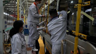 Установка оконных панелей на микроавтобус на заводе во время организованной СМИ экскурсии в городе Шиянь в центральной китайской провинции Хубэй 10 мая 2023 года. (Andy Wong/AP Photo)
