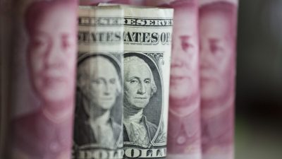 Китайские банкноты номиналом ¥100 и доллар США, Пекин, 6 января 2017 г. (Fred Dufour/AFP via Getty Images)