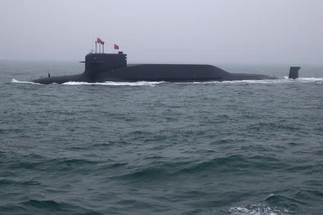 Атомная подводная лодка типа 094 «Цзинь» класса «Лонг Март 15» ВМС Народно-освободительной армии Китая (НОАК) участвует в военно-морском параде в честь 70-й годовщины основания Военно-морских сил НОАК в море близ Циндао, в провинции Шаньдун на востоке Китая, 23 апреля 2019 года. (Mark Schiefelbein /Pool/AFP/via Getty Images)
