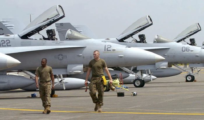 12 октября 2006 года военнослужащие авиации морской пехоты США проходят мимо истребителей F-18 hornets из 122-й истребительно-штурмовой эскадрильи морской пехоты США после того, как они приземлились на авиабазе Кларк, бывшей американской базе, в Ивакуни, Япония, для участия в двухнедельных совместных военных учениях с филиппинскими коллегами, получивших название Talon Vision 2007. (Jay Directo /AFP via Getty Images)