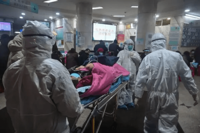 Медицинский персонал одет в защитную одежду от COVID-19 в больнице Красного Креста в Ухане, Китай, 25 января 2020 г. (Hector Retamal/AFP via Getty Images)