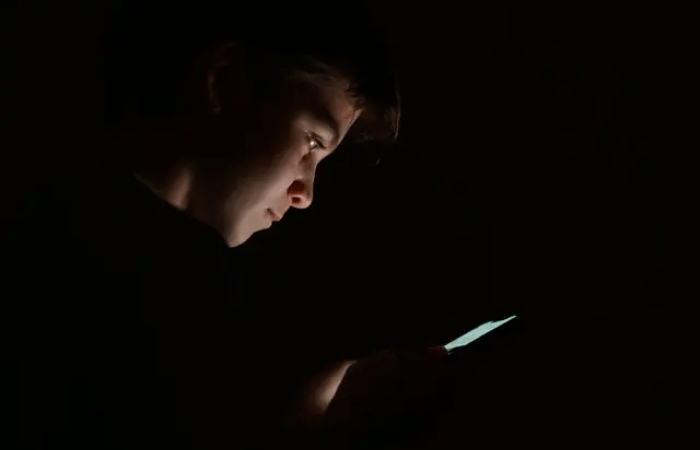 Подросток смотрит на экран мобильного телефона. (Leon Neal/Getty Images)