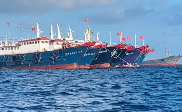 Китайские суда, предположительно укомплектованные бойцами китайской морской милиции, видны у рифа Уитсун в Южно-Китайском море 27 марта 2021 года. (Filipine Coast Guard/National Task Force-West Philippine Sea/Handout via Reuters)
