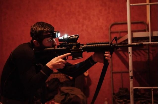Украинский военнослужащий проверяет свой американский карабин M4A1 после чистки на базе в Донецкой области, Украина, 23 февраля 2023 года. (Yasuyoshi Chima/AFP/Getty Images)