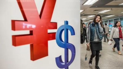 Женщина проходит мимо символов китайского юаня и доллара США в Гонконге 28 ноября 2012 года. (Philippe Lopez/AFP via Getty Images)