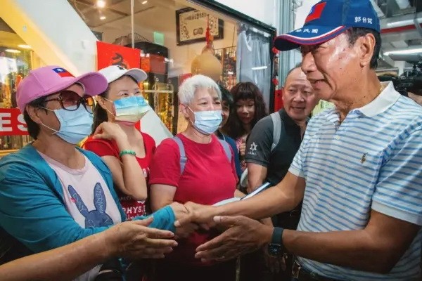 Независимый кандидат в президенты Тайваня и основатель компании Foxconn Терри Гоу (справа) приветствует сторонников во время предвыборной компании на традиционном рынке в Тайбэе 11 августа 2023 года. (Sam Yeh/AFP via Getty Images)