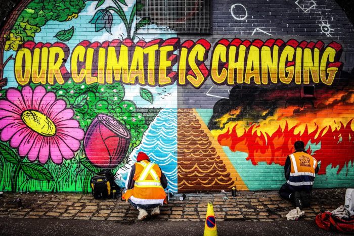 Уличные художники рисуют фреску в рамках конкурса Grantham Climate Art Prize 2021 на стене рядом с местом проведения климатического саммита COP26 в Глазго, Шотландия, 13 октября 2021 года. (Andy Buchanan/AFP via Getty Images)