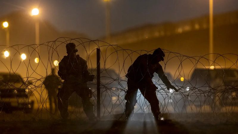 Войска Национальной гвардии Техаса установили колючую проволоку против сотен иммигрантов, которые въехали в Соединённые Штаты из Мексики 9 мая 2023 года в Эль-Пасо, штат Техас. (John Moore/Getty Images)