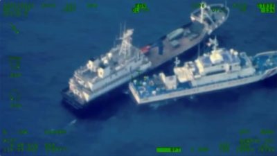 Судно китайского ополченчения top и филиппинское судно береговой охраны BRP Cabra приближаются ко Второй отмели Томаса, которую местные называют Аюнгин, в спорном Южно-Китайском море 22 октября 2023 года. (Armed Forces of the Philippines via AP)