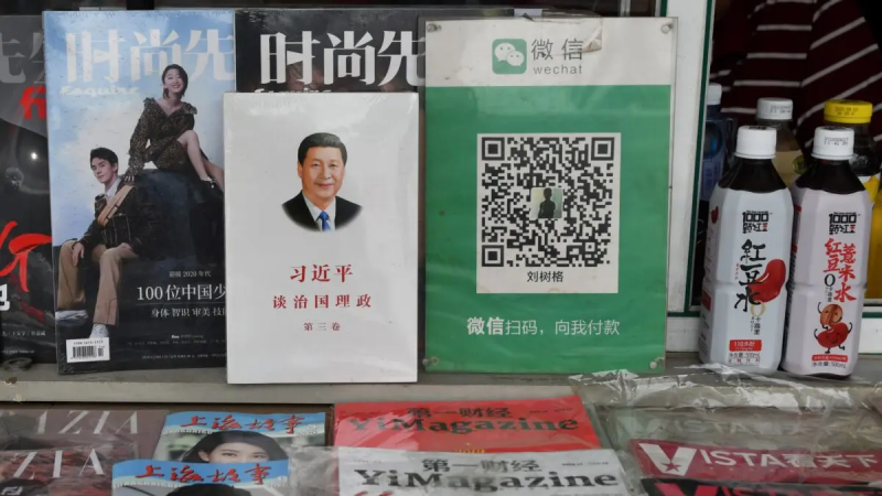 QR-код платежа для Wechat Pay (справа) рядом с книгой о китайском лидере Си Цзиньпине под названием «Си Цзиньпин: Управление Китаем» на газетном киоске в Пекине 18 сентября 2020 г. (Greg Baker/AFP via Getty Images)