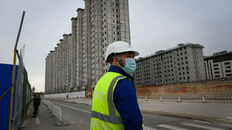 Кризис в секторе недвижимости Китая в долгосрочной перспективе отразится на других секторах Рабочий возле строительной площадки в Пекине 26 апреля 2022 года. (Wang Zhao/AFP via Getty Images)